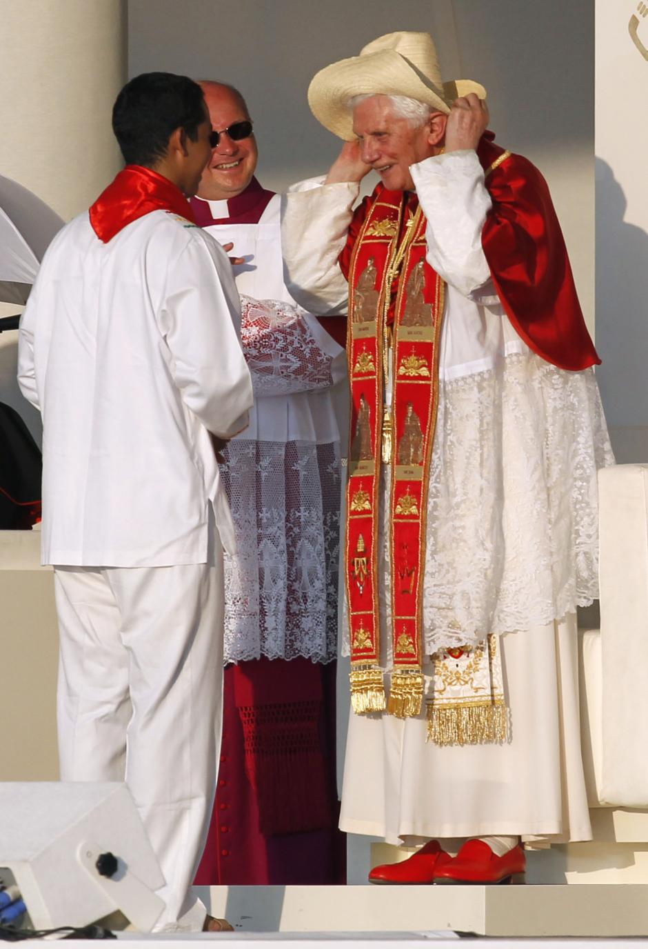 Pope Benedict XVI puts on a hat presented to him by a young man representing the youth from Latin America in Madrid' Thursday Aug. 18, 2011. The Pontiff leaves Madrid on the occasion of the Catholic Church's World Youth Day.