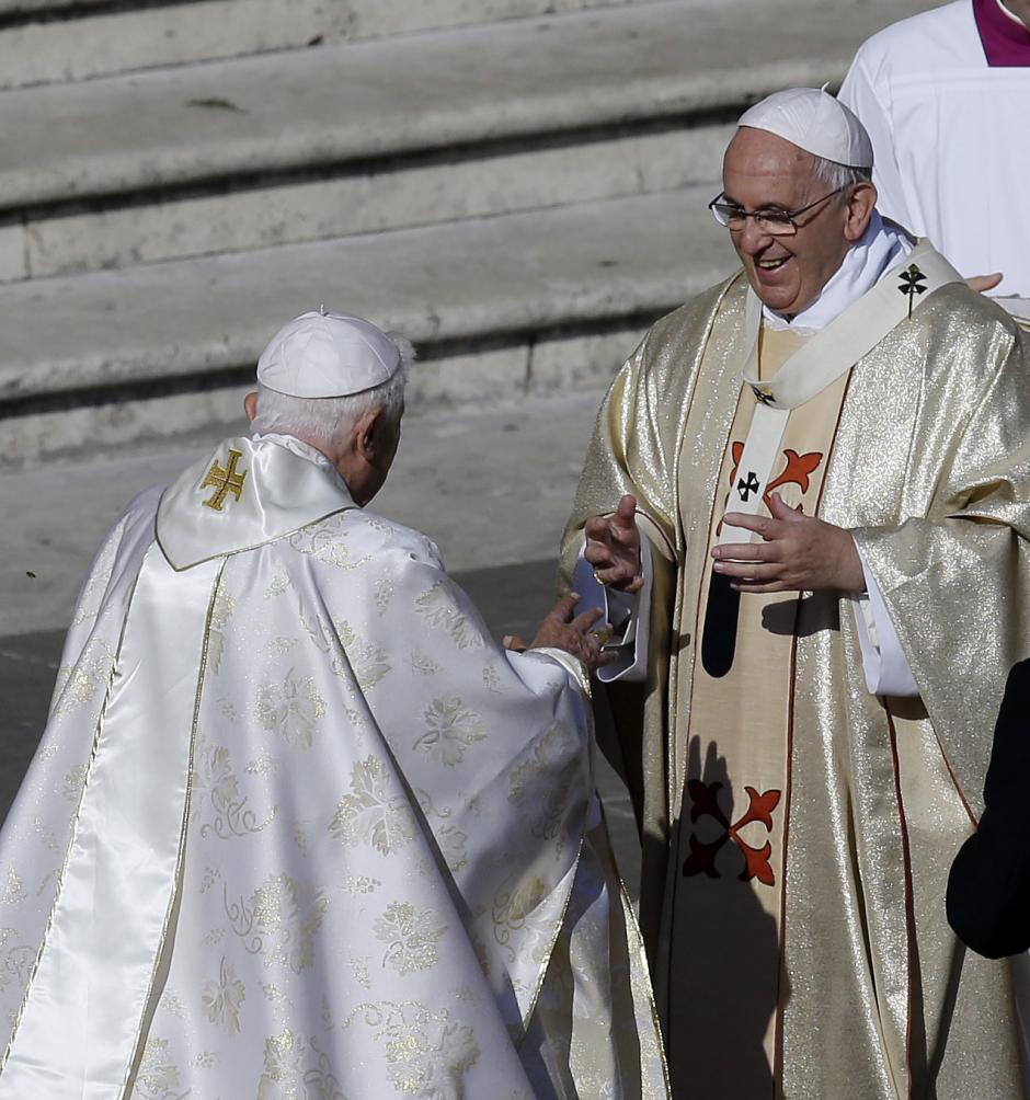 Pope Emeritus Benedict XVI, left, greets Pope Francis prior to the start of the beatification ceremony of Pope Paul VI and a mass for the closing of a two-week synod on family issues, in Saint Peter's Square at the Vatican, Sunday, Oct. 19, 2014. (