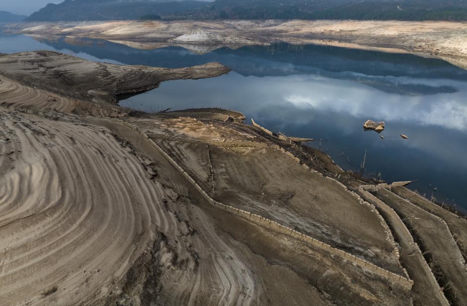 The roof of an old house, submerged three decades ago when a hydropower dam flooded the valley, is photographed emerged due to drought at the Lindoso reservoir, in northwestern Spain, Saturday, Feb. 12, 2022.