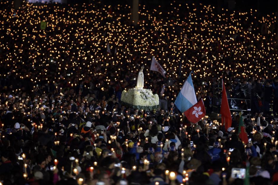 The statue of Our Lady of Fatima is carried through the crowd during a candle light vigil prayer at the Sanctuary of Our Lady of Fatima Friday, May 12 2017, in Fatima, Portugal.