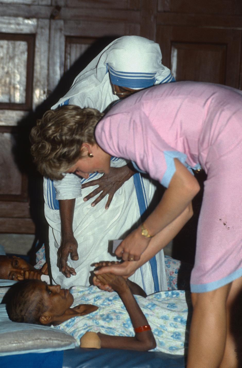 Diana, Princess of Wales talks to a dying patient as she visits Mother Teresa'a Hospice in Calcutta during a visit to India on February 15, 1992.
