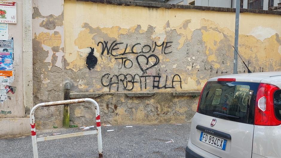 Un grafiti da la bienvenido a la Garbatella