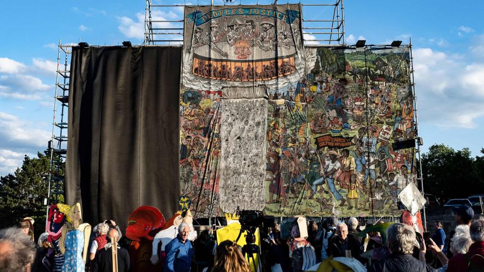 Mural del colectivo indonesio Taring Padi titulado 'La justicia del pueblo' mientras personal de la exposición de arte contemporáneo Documenta lo cubre con una lona negra en Kassel, Alemania