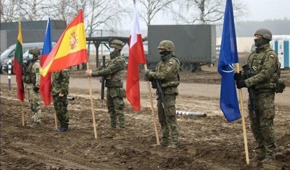 Un militar español exhibe la bandera española con otros abanderados de la OTAN en Lituania en 2020, durante los ejercicios ‘Brilliant Jump’
