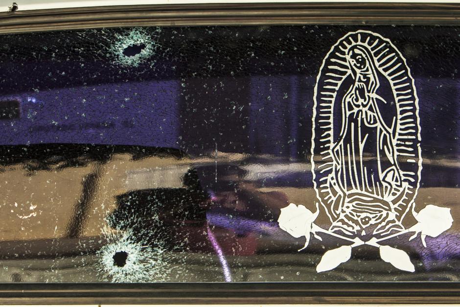 The rear windshield of a vehicle is held together by a transparent film with an image of the Virgin of Guadalupe, after being struck by bullets in Culiacan, Mexico, Tuesday, Feb. 7, 2017.