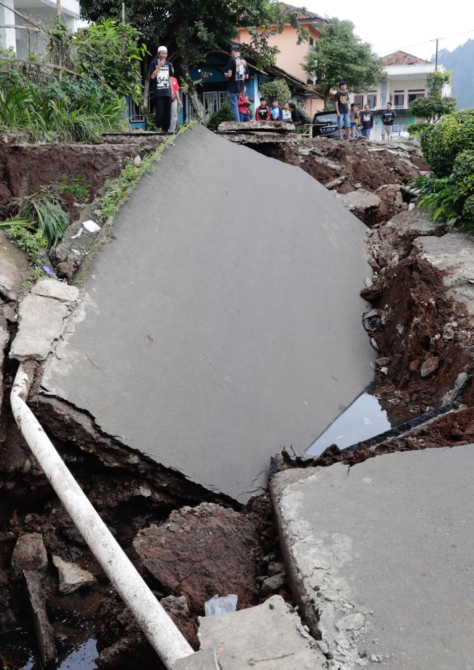 Un hombre pasa junto a una carretera colapsada por un terremoto de magnitud 5,6, en Cianjur.