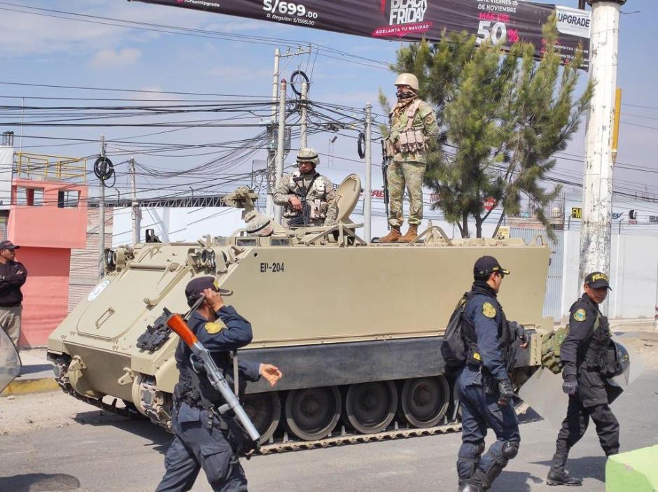 Soldados patrullan una de las calles de Arequipa al paso de un tanque