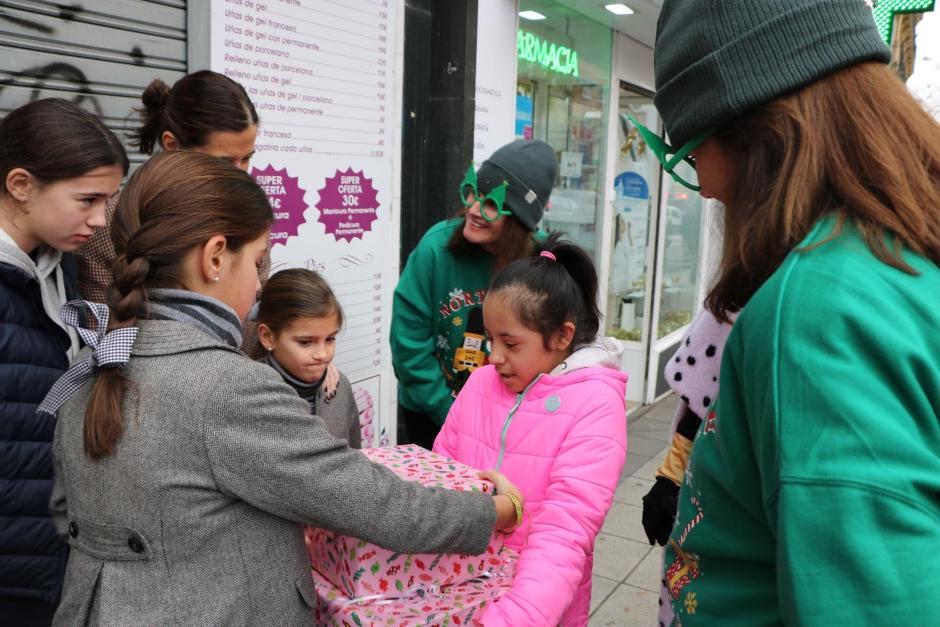 María Fernanda recibe ilusionada su regalo junto con la familia voluntaria que la acompaña