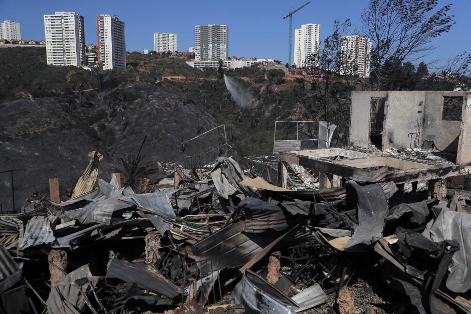 View of houses destroyed by a forest fire that affected the hills of Vina del Mar, in the Valparaiso region, Chile, taken on December 23, 2022. - At least two people died and some 400 homes have been damaged or destroyed in a fire that broke out Thursday in the Chilean seaside resort of Vina del Mar, prompting the government to declare a state of emergency. (Photo by JAVIER TORRES / AFP)