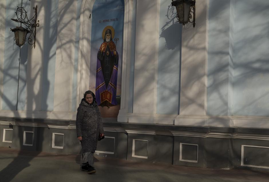 A woman walks past a Christian Orthodox church in Mykolaiv, Ukraine, on Wednesday, March 30, 2022. The United Nations chief says one-quarter of humanity -- two billion people -- are living in conflict areas today, and the world is facing the highest number of violent conflicts since the end of World War II in 1945. (AP Photo/Petros Giannakouris)