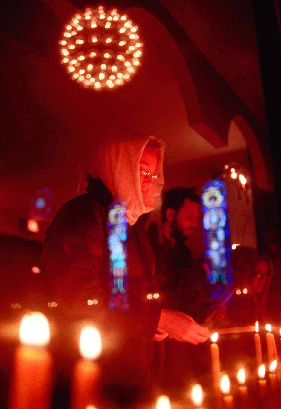 Erika Johnson lights candles in the sanctury of the Holy Ressurection Serbian Orthodox Church in Chicago before the start of a vigil in the wake of NATO bombings in Yugoslavia Wednesday evening, March 24, 1999. NATO Thursday promised more airstrikes on Yugoslavia after a punishing first round that killed at least 10 people. (AP Photo/Chicago Tribune, John Lee)