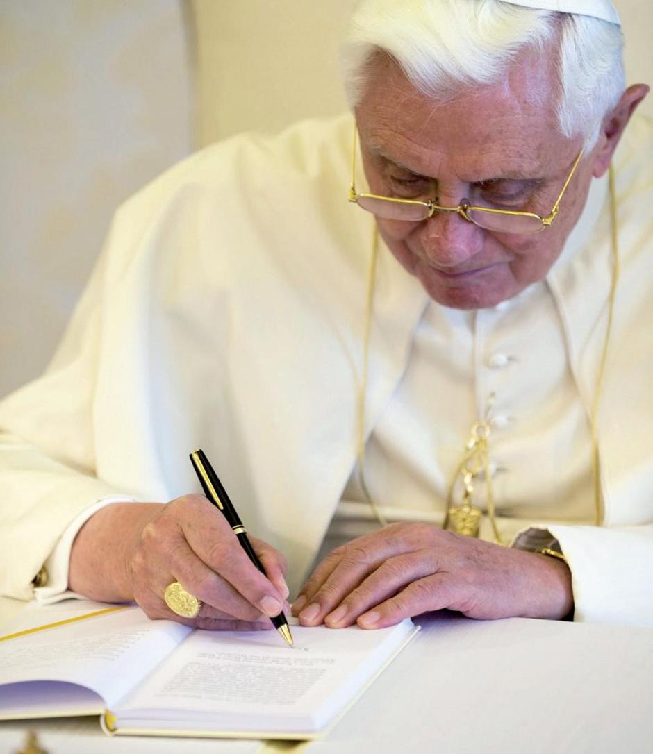 Una imagen de Benedicto XVI, firmando un libro