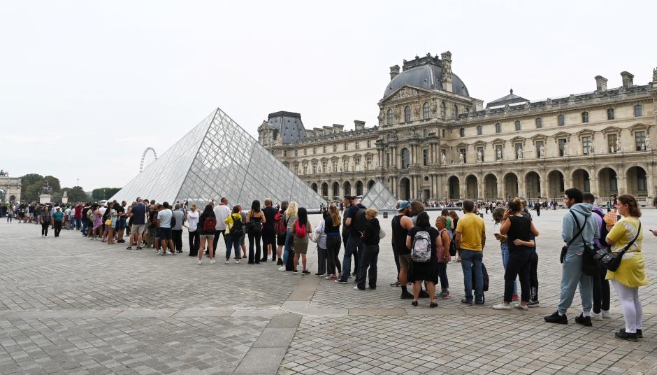 Los visitantes hacen cola para acceder al Louvre en agosto de 2022