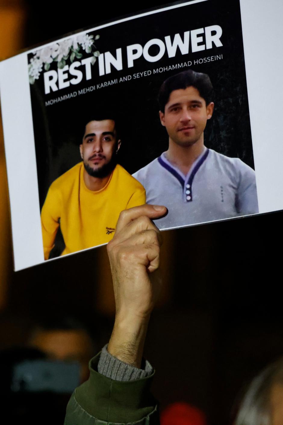 Una manifestante sostiene un cartel con retratos de los manifestantes iraníes Mohammad Mehdi Karami (izquierda) y Seyed Mohammad Hosseini