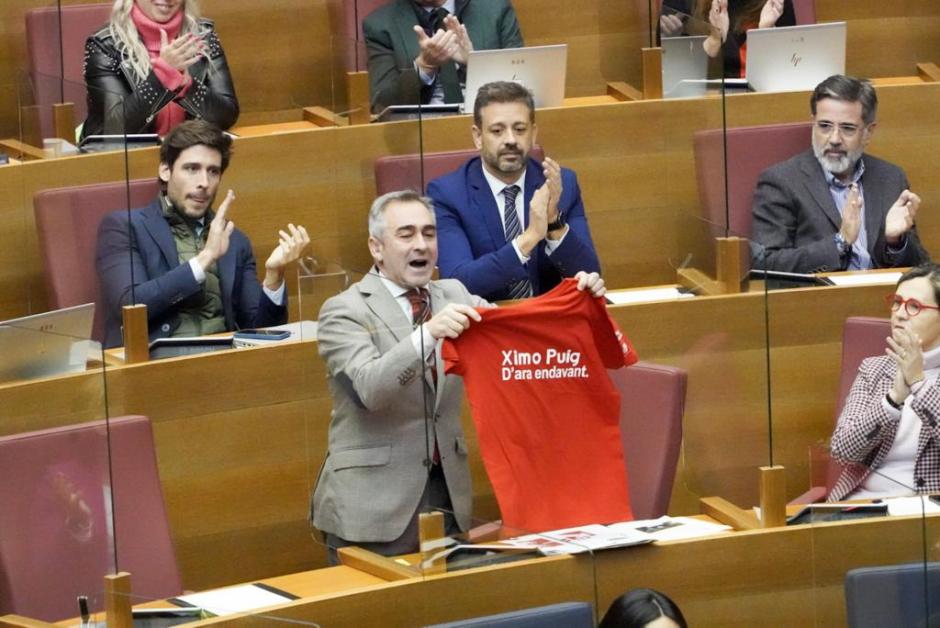 El diputado del PP Miguel Barrachina muestra a Puig una camiseta de una campaña suya investigada por la Guardia Civil.