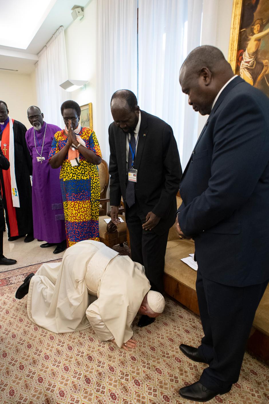 In this photo taken and released on April 11, 2019 by the Vatican Press Office, Vatican Media, Pope Francis (Bottom) kneels to kiss the feet of South Sudan's President Salva Kiir Mayardit (C) and South Sudan opposition leader Riek Machar (R) at the Pope's Santa Marta residence in the Vatican. - Pope Francis on April 11 knelt and kissed the feet of leaders of South Sudan at the end of a two-day retreat to help them solidify a peace agreement. (Photo by Handout / VATICAN MEDIA / AFP) / RESTRICTED TO EDITORIAL USE - MANDATORY CREDIT "AFP PHOTO / VATICAN MEDIA" - NO MARKETING NO ADVERTISING CAMPAIGNS - DISTRIBUTED AS A SERVICE TO CLIENTS ---