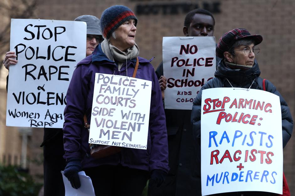 Varios manifestantes sostienen pancartas contra los delitos policiales durante el juicio contra el expolicía David Carrick