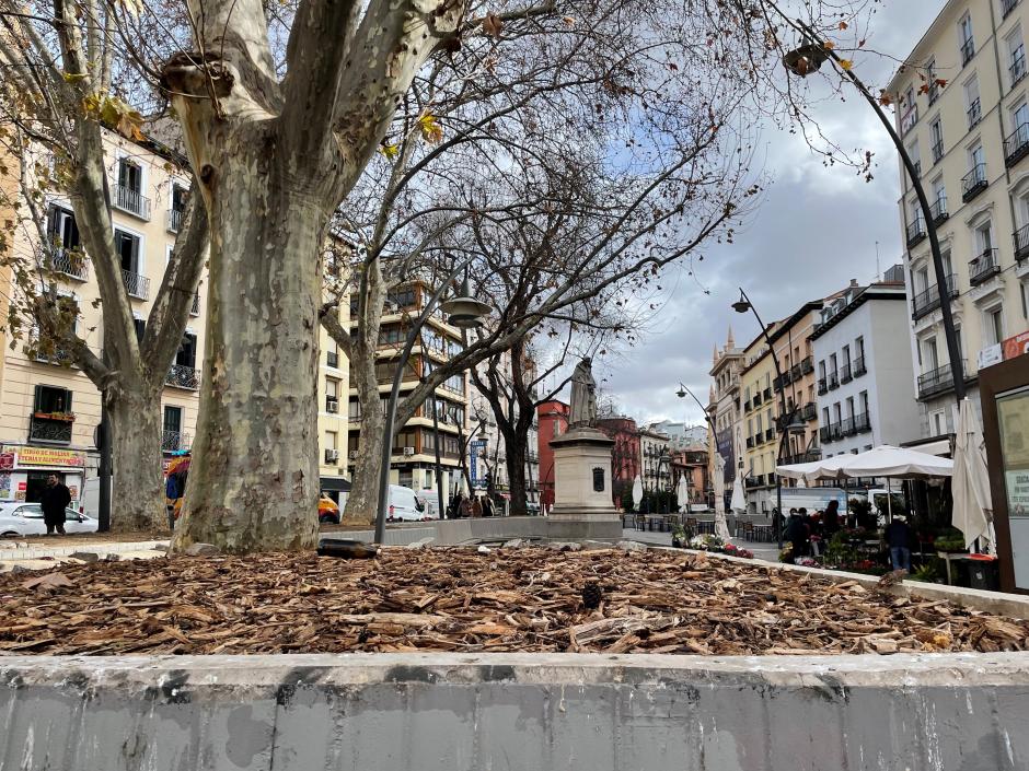 Vista de la estatua de Tirso de Molina con una botella tirada en el suelo