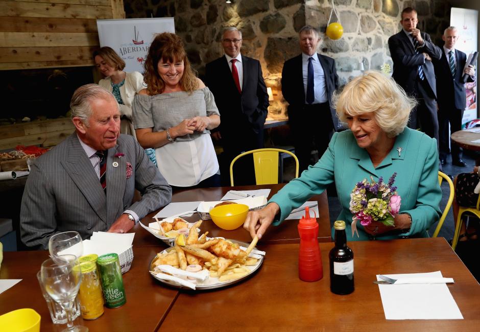 Prince Charles of Wales and Duchess of Cornwall eating fish and chips on the annual visit to Wales.