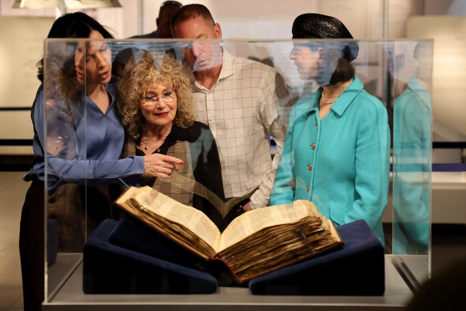 People look at the Codex Sassoon, the earliest most complete edition of the Hebrew Bible, on March 22, 2023 at the ANU Museum of the Jewish People in Tel Aviv. - The manuscript, which is believed to be more than 1,000 years old, is set to be sold at auction in New York for up to an estimated $50 million. (Photo by JACK GUEZ / AFP)