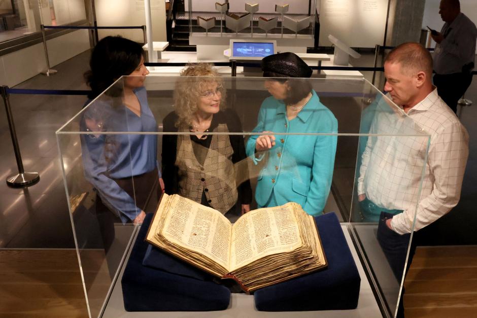 People look at the Codex Sassoon, the earliest most complete edition of the Hebrew Bible, on March 22, 2023 at the ANU Museum of the Jewish People in Tel Aviv. - The manuscript, which is believed to be more than 1,000 years old, is set to be sold at auction in New York for up to an estimated $50 million. (Photo by JACK GUEZ / AFP)