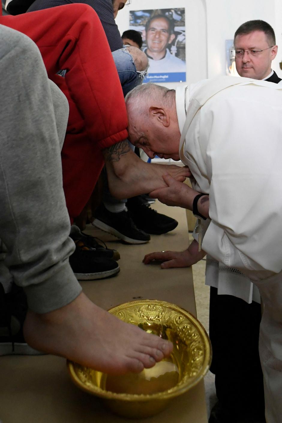 This photo taken and issued as a handout on April 6, 2023 by the Vatican Media shows Pope Francis kissing the foot of a detainee, while performing the "Washing of the Feet" of twelve young detainees at the "Casal del Marmo" Penal Institute for minors in Rome, as part of celebrations of the Holy Week. (Photo by Handout / VATICAN MEDIA / AFP) / RESTRICTED TO EDITORIAL USE - MANDATORY CREDIT "AFP PHOTO / VATICAN MEDIA" - NO MARKETING NO ADVERTISING CAMPAIGNS - DISTRIBUTED AS A SERVICE TO CLIENTS