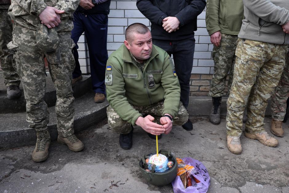 Un soldado ucraniano espera junto a sus canastas con comida tradicional de Pascua y espera ser bendecido en una iglesia durante la Pascua ortodoxa