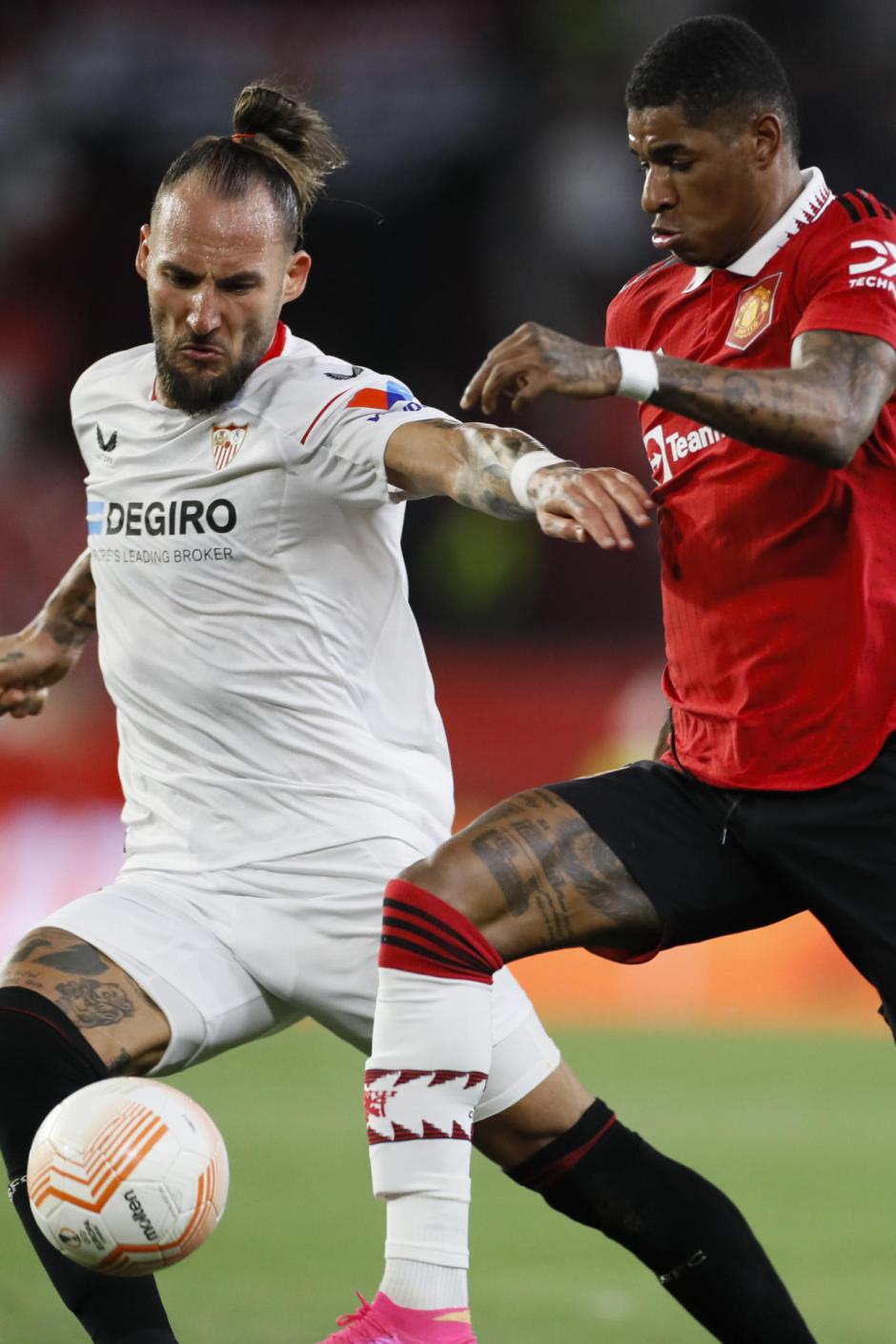 Nemanja Gudelj (i), del Sevilla, y Rashford, del Manchester, durante el partido de vuelta de cuartos de final de Liga Europa que enfrenta este jueves al Sevilla FC y al Manchester United