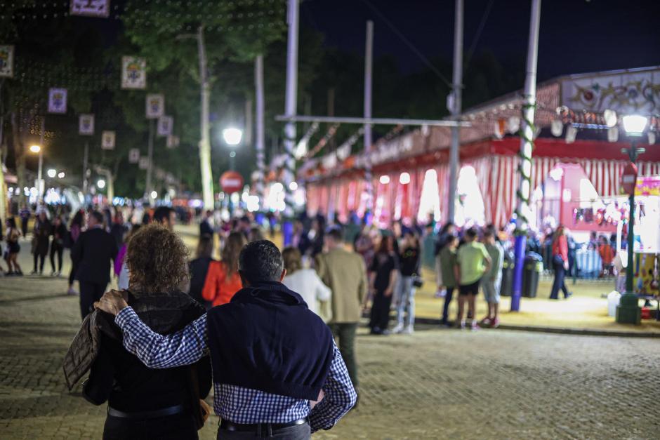 Una pareja pasea por el Real de la Feria tras 'el alumbrao'