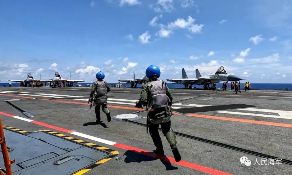 Pilotos chinos se disponen a abordar sus aviones de combate en un portaviones del ELP