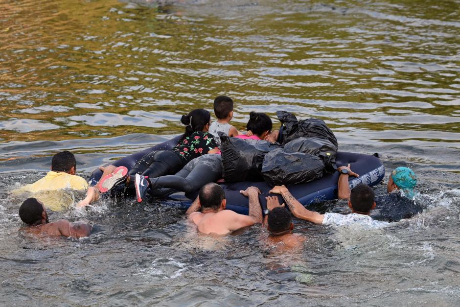 Migrant people try to get to the US through the Rio Grande as seen from Matamoros, state of Tamaulipas, Mexico, on May 11, 2023. - A surge of migrants is expected at the US-Mexico border cities as President Biden administration is officially ending its use of Title 42. On May 11, President Joe Biden's administration will lift Title 42, the strict protocol implemented by previous president Donald Trump to deny entry to migrants and expel asylum seekers based on the Covid pandemic emergency. (Photo by Alfredo ESTRELLA / AFP)