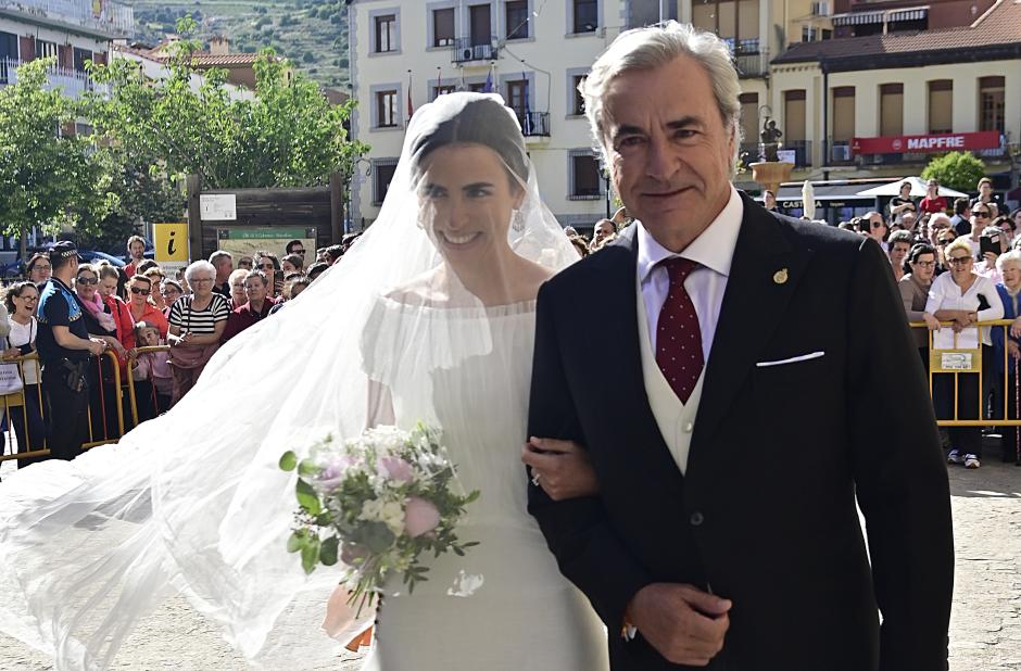 La novia, del brazo de su padre y padrino, Carlos Sainz
