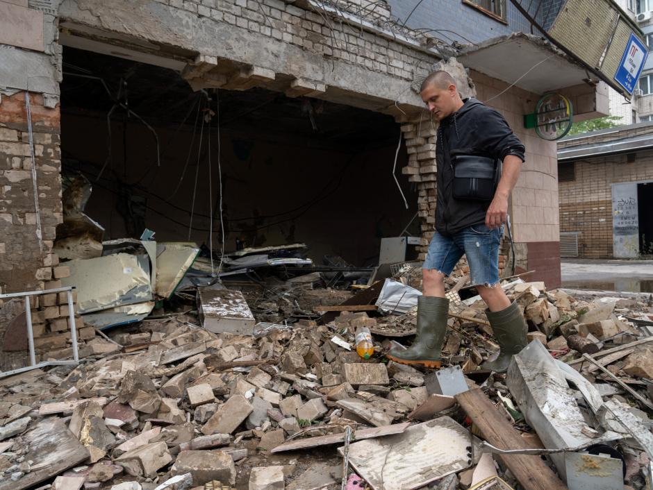 Un residente local limpia los escombros de una tienda destruida después de un bombardeo ruso en Jerson