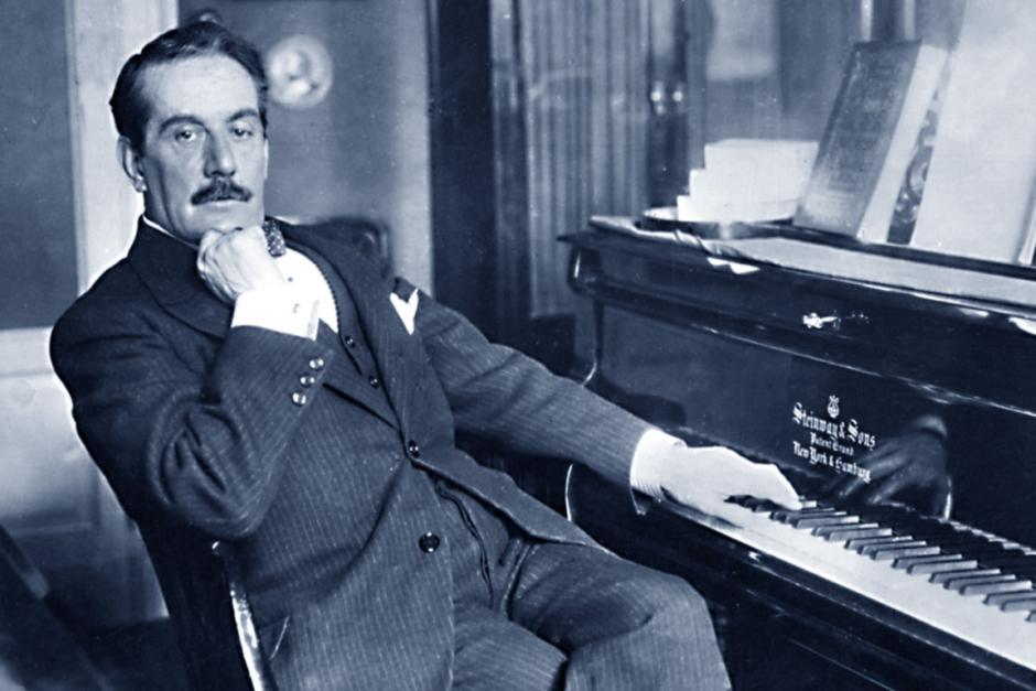 El compositor Giacomo Puccini junto a su piano