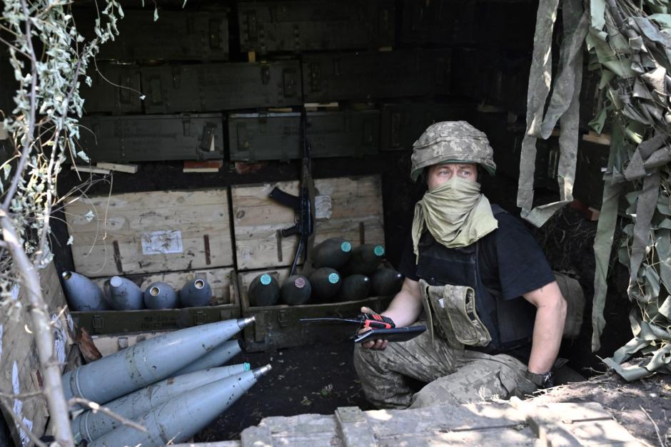 A Ukrainian artilleryman sits next to 152 mm shells at a position on the front line near Bakhmut, eastern Ukraine, on July 20, 2023, amid the Russian invasion of Ukraine. (Photo by Genya SAVILOV / AFP)