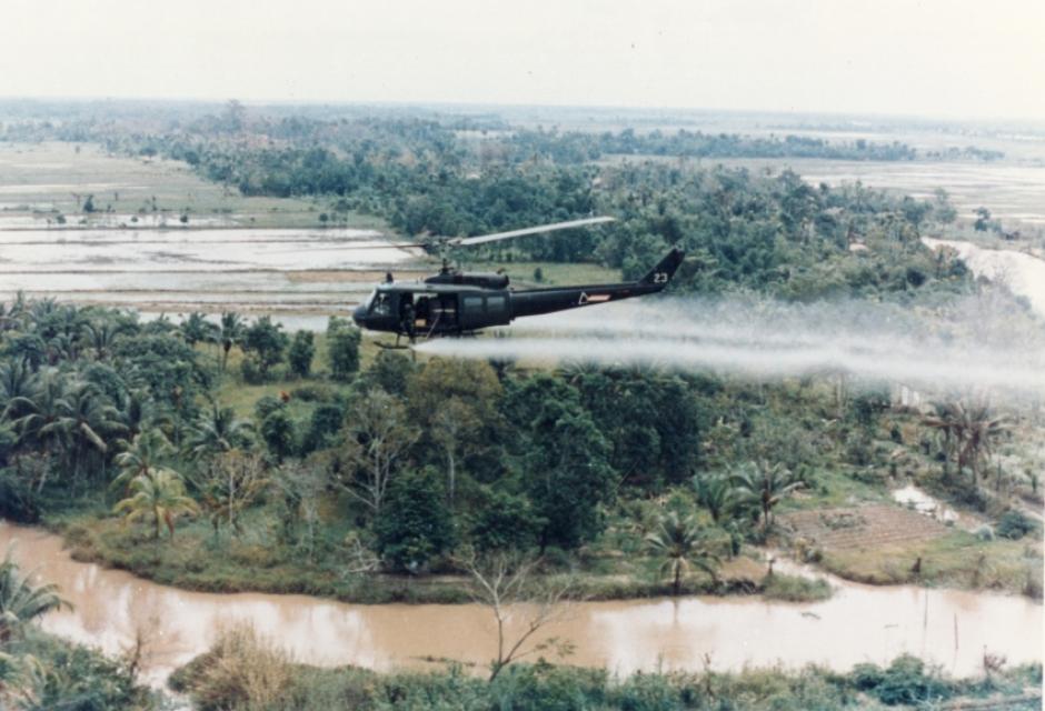 Un helicóptero Bell UH-1 Iroquois del Ejército de Estados Unidos rociando Agente Naranja sobre campos de cultivo en Vietnam