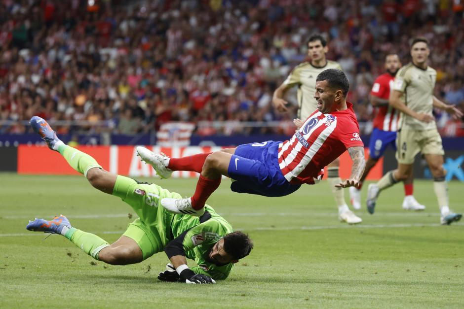 El delantero del Atlético de Madrid Ángel Correa (d) cae ante el portero André Ferreira, del Granada, durante el partido