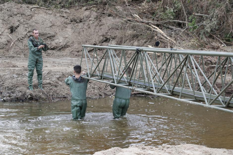 Militares colocan una de las pasarelas peatonales que permite cruzar el río en Aldea del Fresno (Madrid)