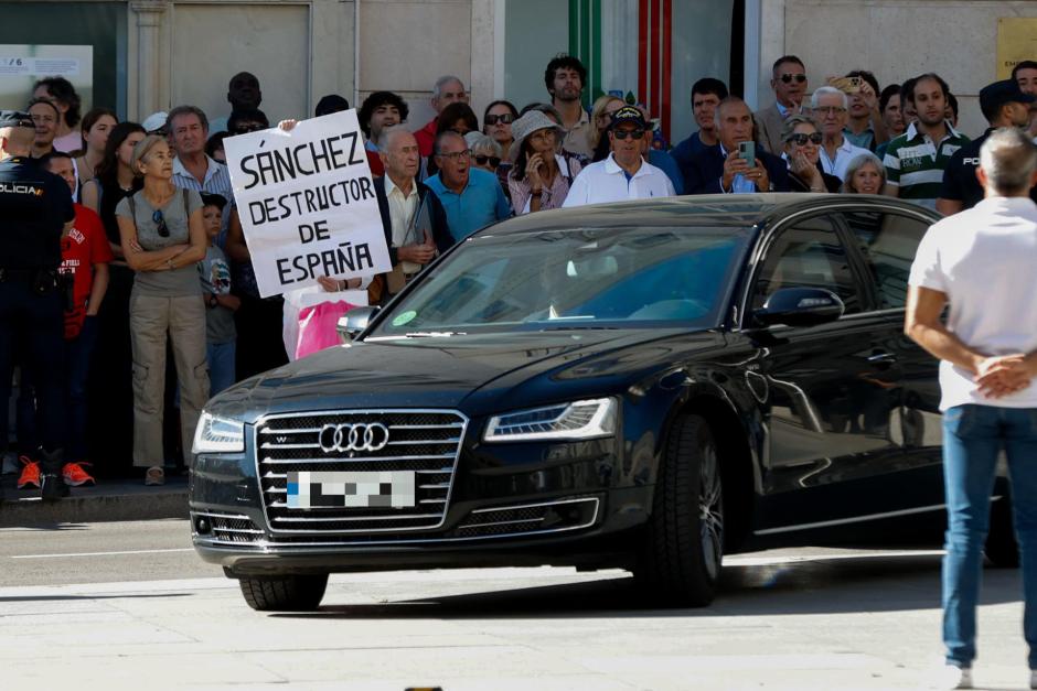 Varias personas observan la llegada del vehículo que traslada al presiente del Gobierno, Pedro Sánchez