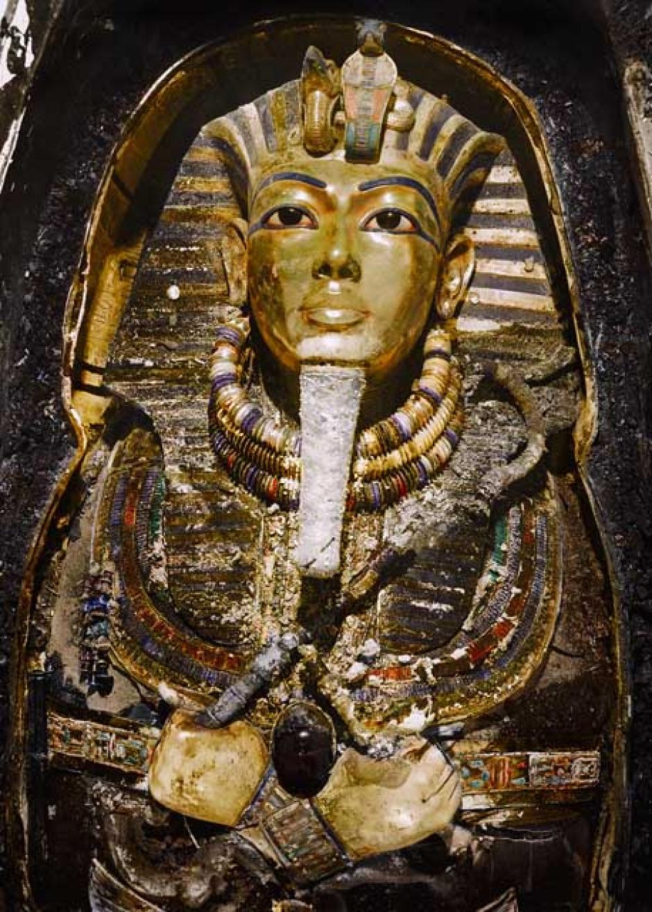 La máscara de oro (Carter nº 256a) in situ sobre la momia del Rey, todavía dentro del tercer ataúd (el más interior) de oro macizo (Carter nº 255).