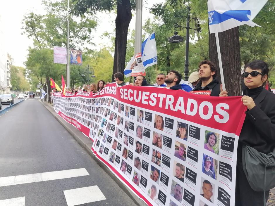 Participantes de la manifestación sostienen una pancarta con imágenes de los secuestrados por Hamás