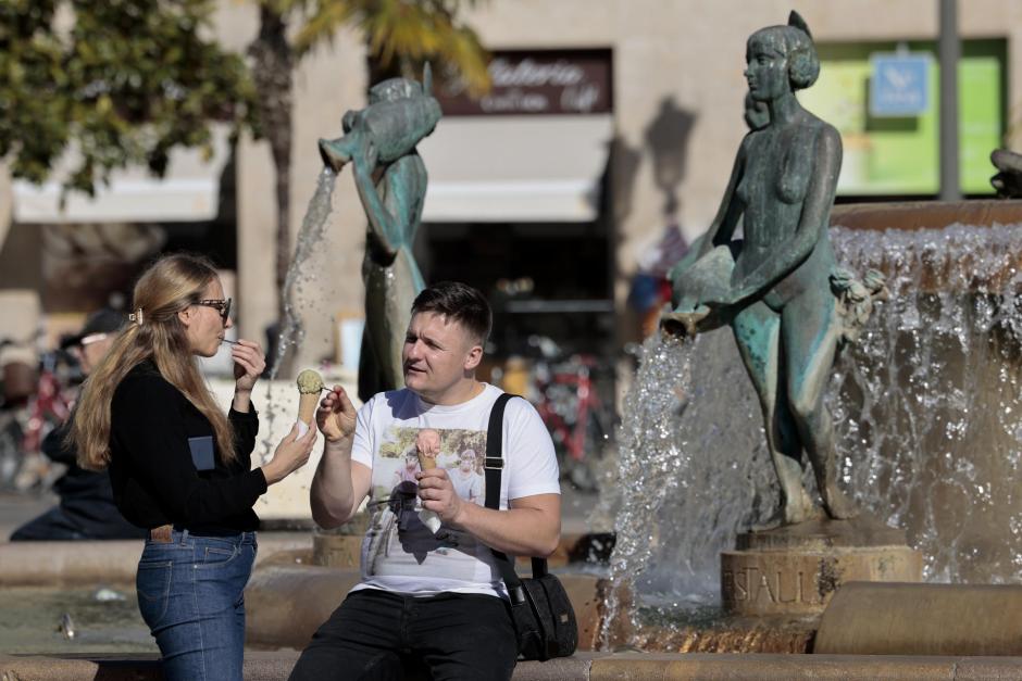 Dos personas disfrutan de un helado junto a una fuente este fin de semana en Alicante