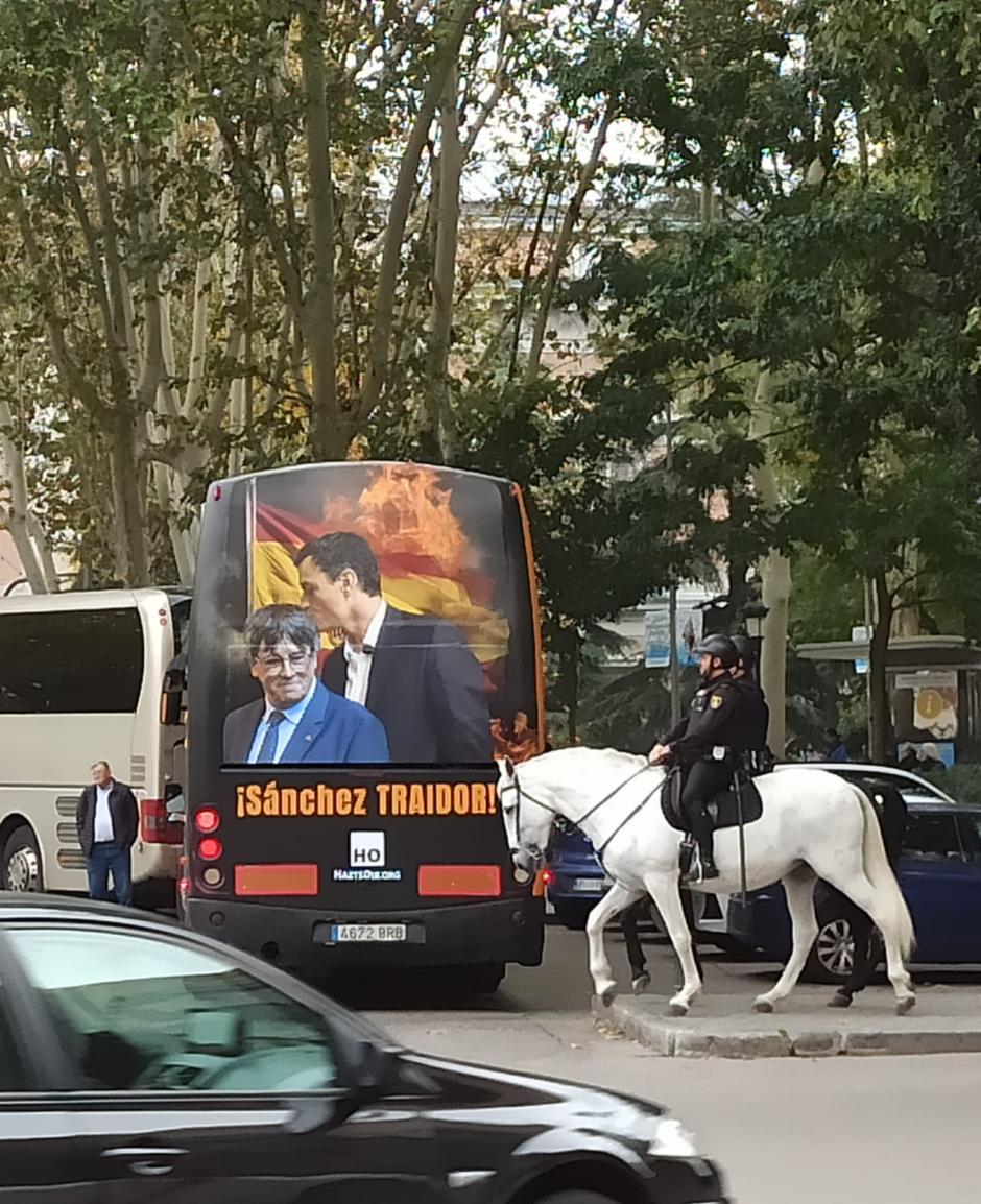 Dos policías a caballo pasan junto a uno de los autobuses del colectivo Hazte Oir que se han sumado a la protesta