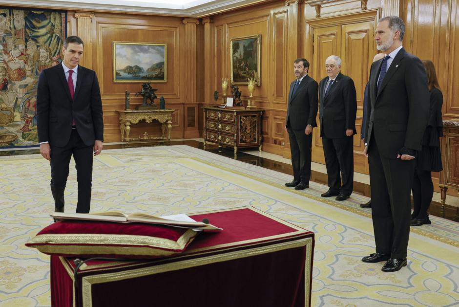 Pedro Sánchez (i) promete su cargo de presidente del Gobierno ante el rey Felipe VI (d) y un ejemplar de la Constitución, este viernes en el Salón de Audiencias del Palacio de la Zarzuela en Madrid