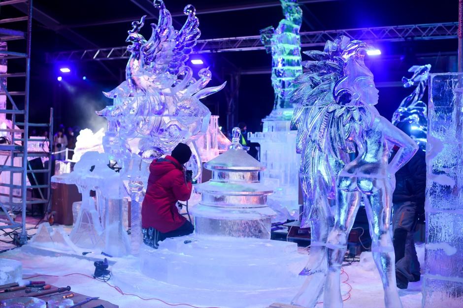 Un operario trabaja con una de las esculturas del Festival de Esculturas de Hielo