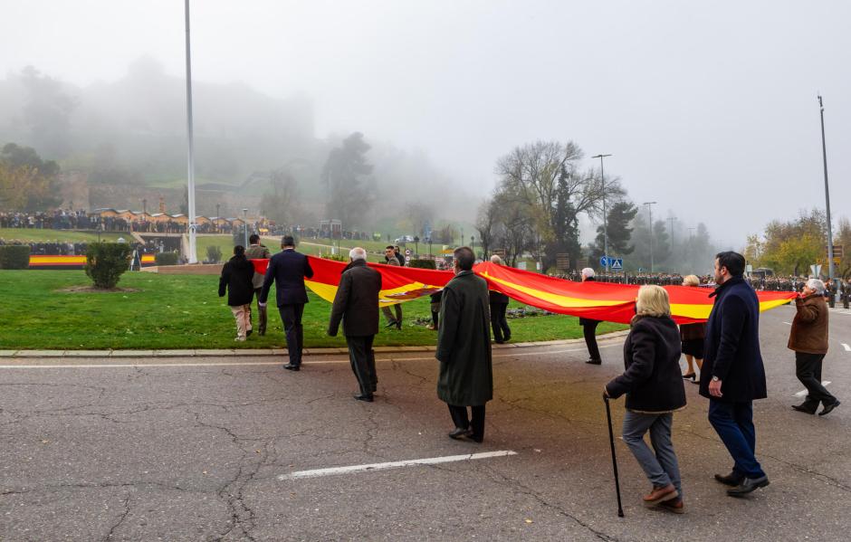 Una gran bandera de España es portada desplegada hasta el mástil donde ondeará a partir de este domingo en Toledo