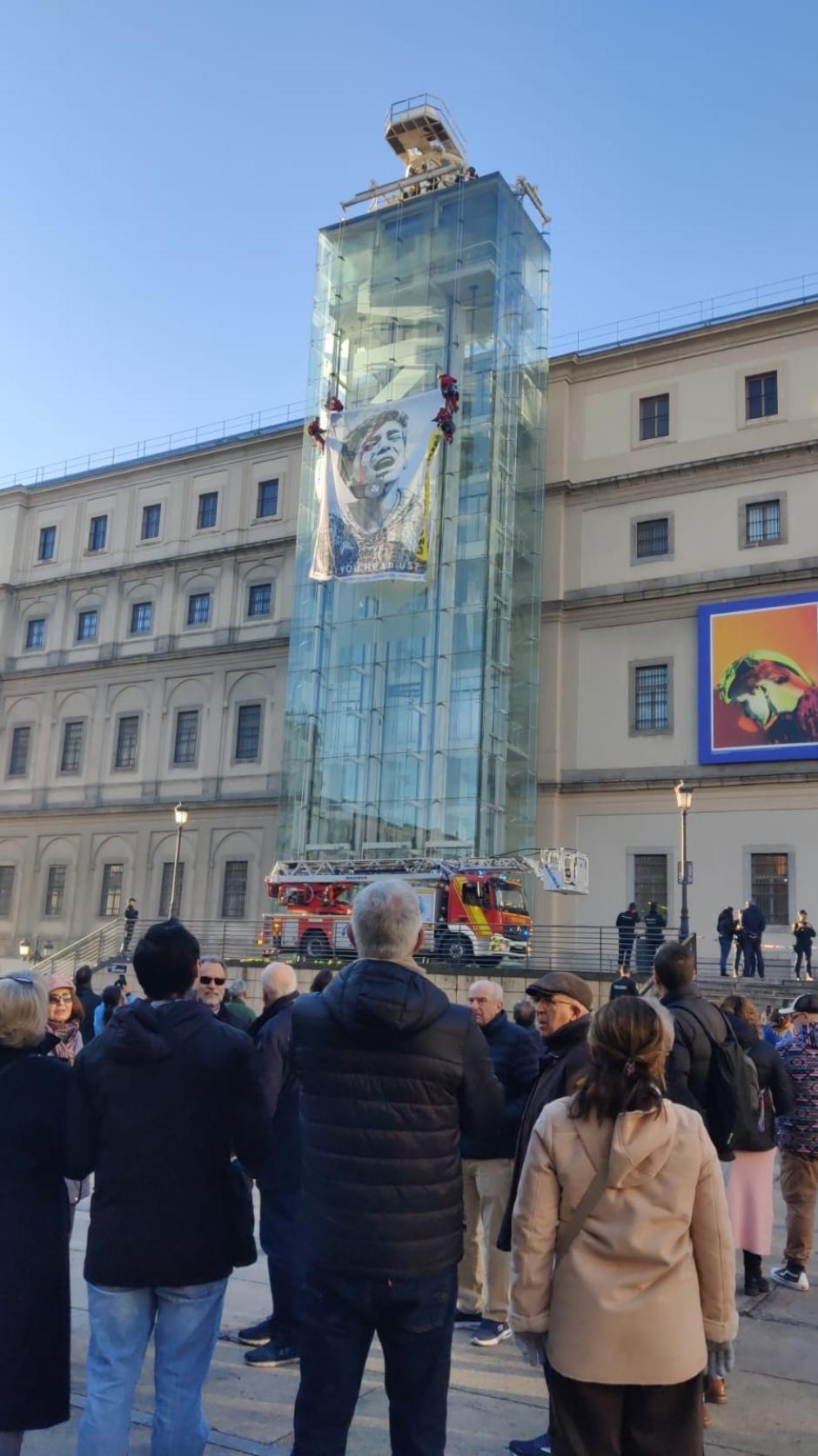 Grupo de personas viendo el momento en el que se desplegaba la lona en el Reina Sofía