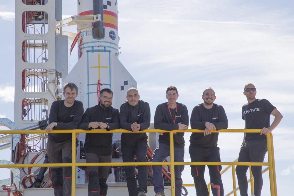 Varios miembros de PLD Space, junto a uno de sus cohetes