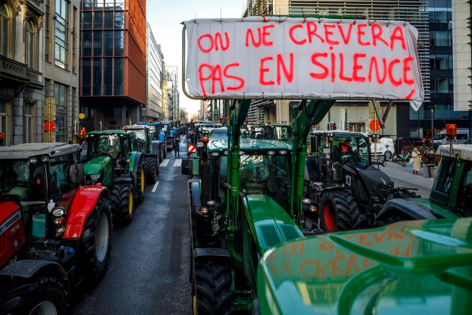 Un tractor con un cartel que dice "No moriremos en silencio" en una calle de Bruselas