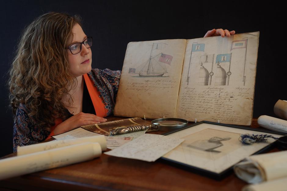 Una empleada de la casa de subastas  muestra una pieza perteneciente al archivo de la familia del reconocido escritor escocés Robert Louis Stevenson